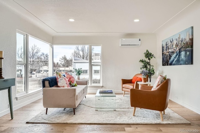 living area featuring recessed lighting, baseboards, wood finished floors, and a wall unit AC