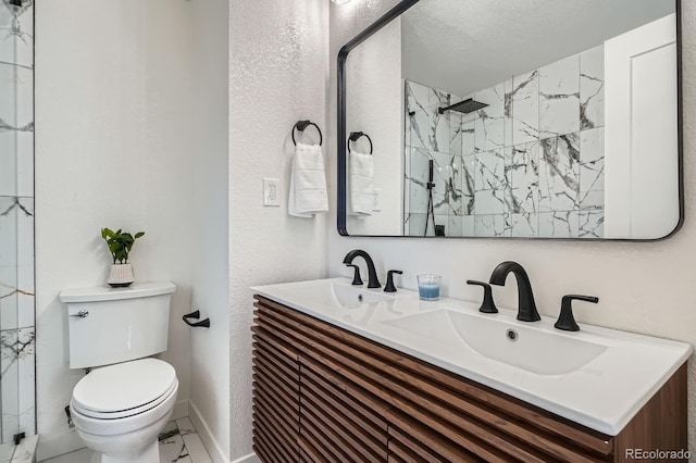 bathroom with a sink, toilet, marble finish floor, and walk in shower