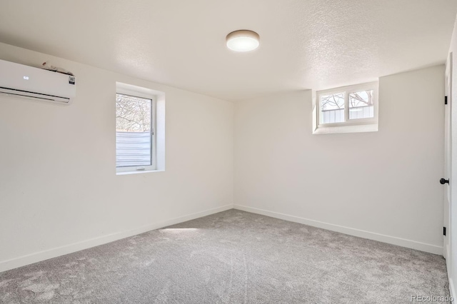 interior space featuring baseboards, carpet floors, a textured ceiling, and an AC wall unit