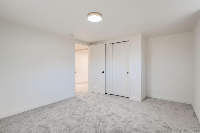 unfurnished bedroom with a closet, carpet flooring, and baseboards