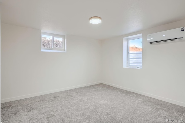 basement with carpet flooring, baseboards, and a wall mounted air conditioner