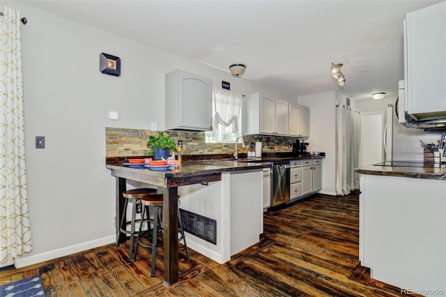 1156 White Stone Way, Fountain, CO 80817 - kitchen with dark wood-type flooring, dishwasher, tasteful backsplash, a peninsula, and a breakfast bar