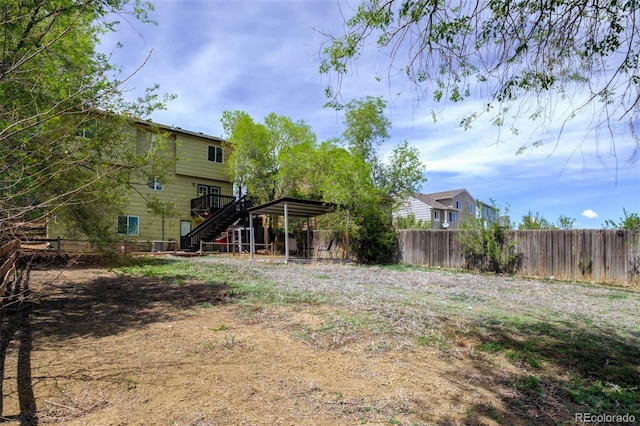 1156 White Stone Way, Fountain, CO 80817 - fenced backyard featuring stairway, a deck, and a detached carport