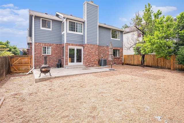 13118 Ash St, Thornton, CO 80241 - rear view of property featuring a patio area, brick siding, a chimney, french doors, and a fenced backyard