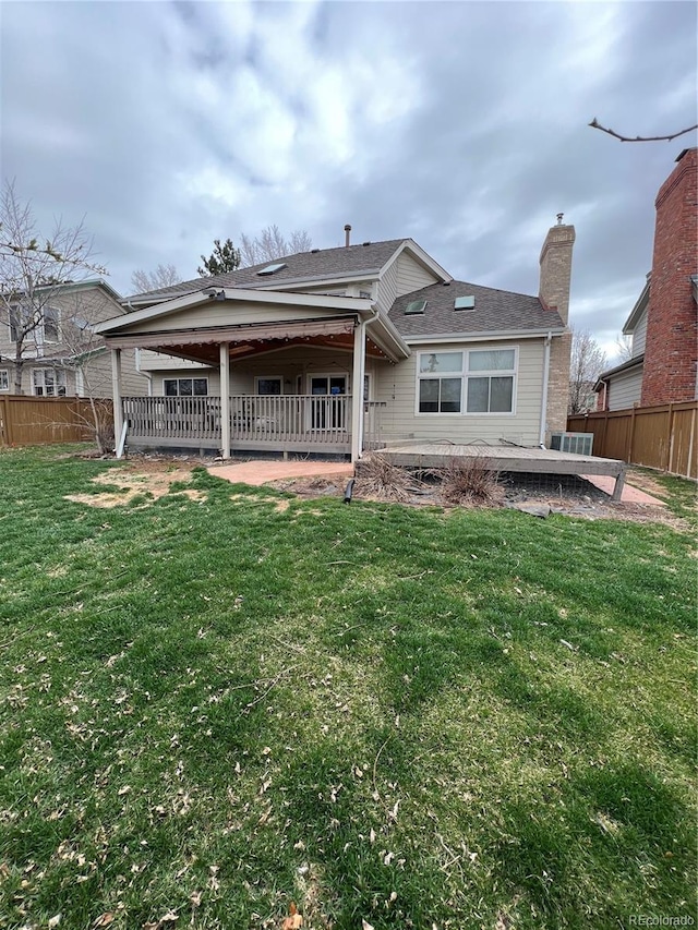 back of house featuring a yard, fence, and a patio