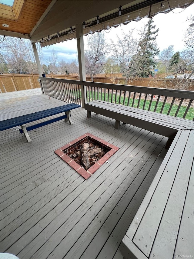 deck featuring an outdoor fire pit and a fenced backyard