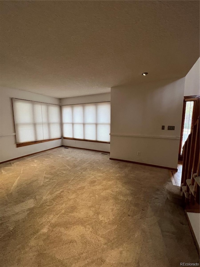 unfurnished living room with a textured ceiling and carpet floors