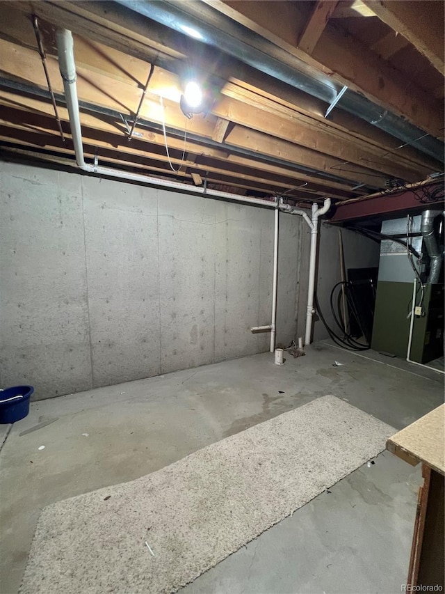 unfinished basement featuring heating unit