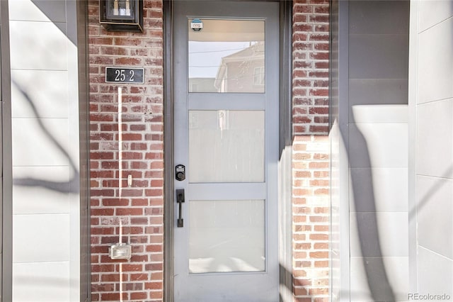 entrance to property with a garage and brick siding