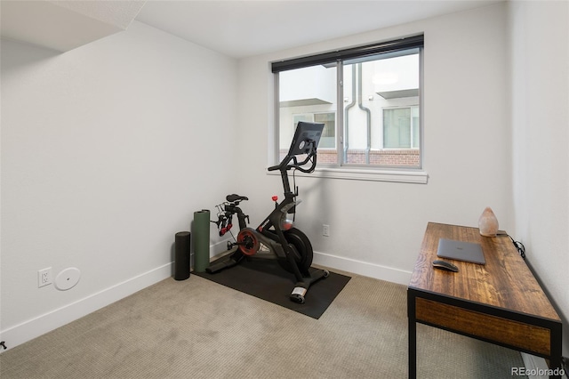 workout room featuring carpet and baseboards