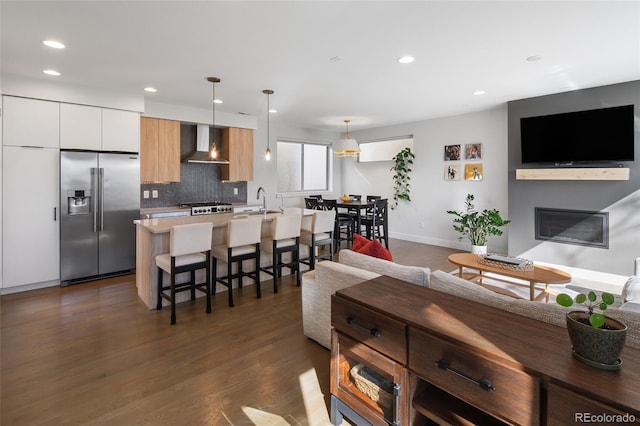 living room with baseboards, a glass covered fireplace, dark wood finished floors, and recessed lighting