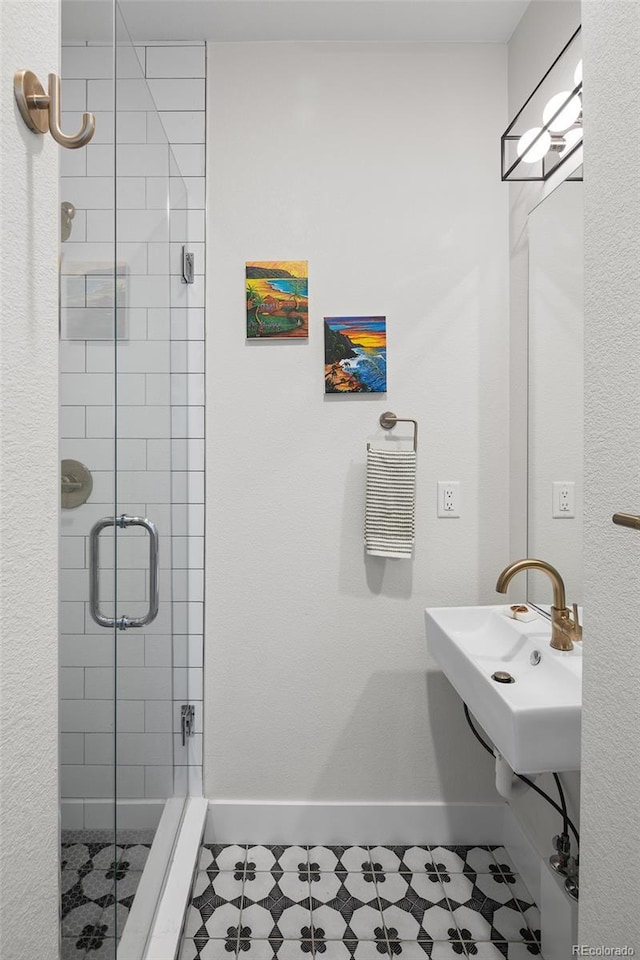 full bathroom featuring a shower stall and baseboards