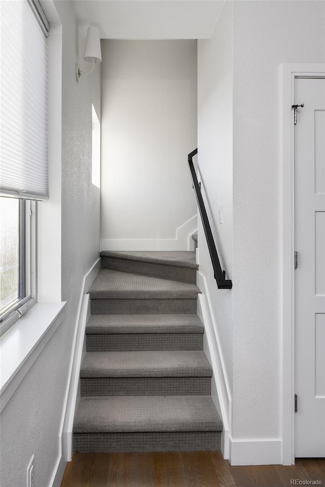 stairway with baseboards and wood finished floors