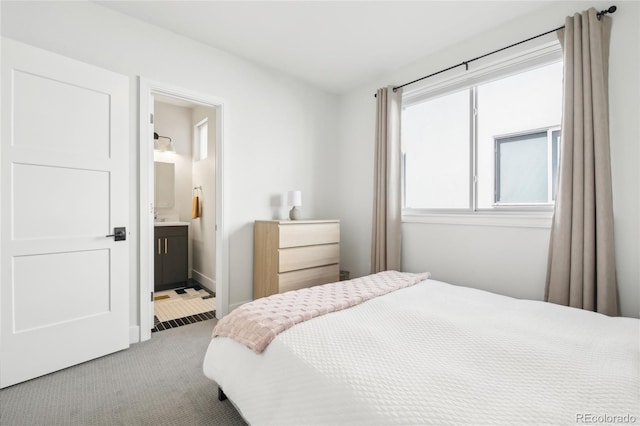 bedroom with ensuite bath and carpet flooring