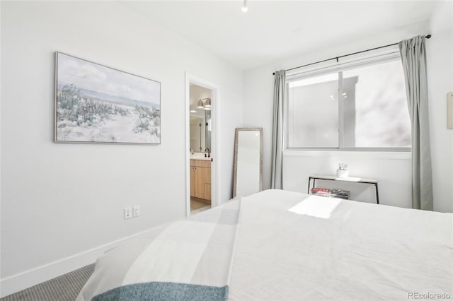 bedroom featuring baseboards and ensuite bathroom