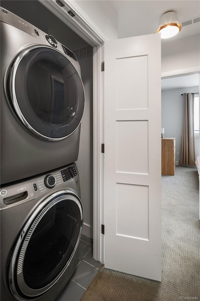 laundry room with stacked washing maching and dryer, carpet, and laundry area