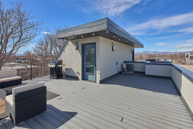 wooden deck with a mountain view, cooling unit, and area for grilling