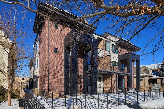 25 S Washington St Unit 2, Denver, CO 80209 - view of snowy exterior with brick siding and a balcony