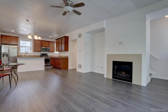 9520 Halstead, Lone Tree, CO 80124 - living area with dark wood-type flooring, ceiling fan, a chandelier, recessed lighting, and a tile fireplace