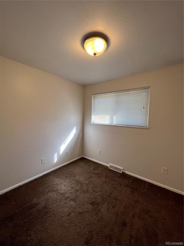 carpeted empty room with a textured ceiling