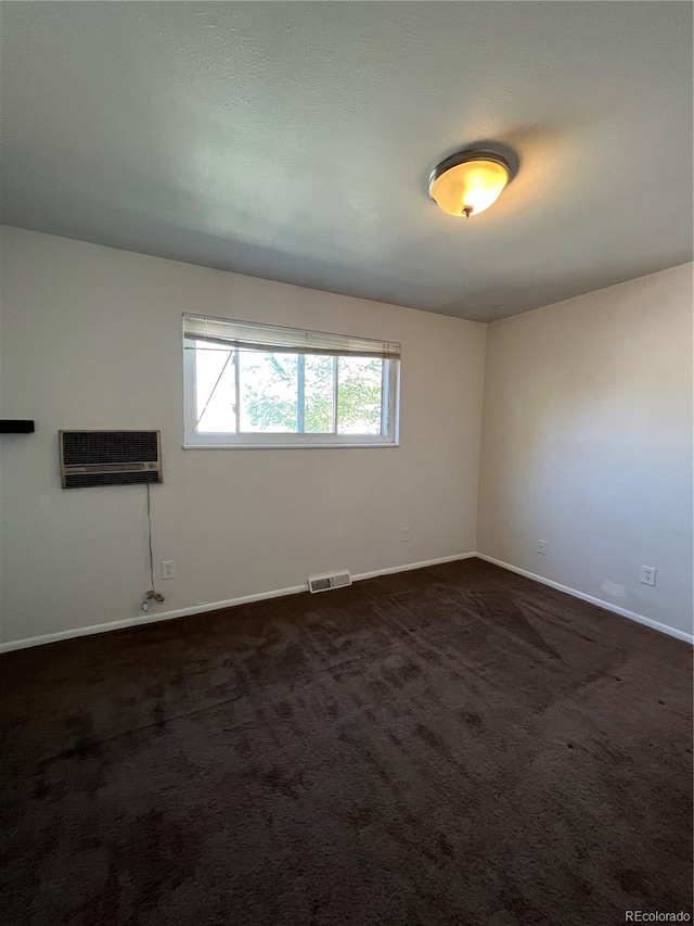 carpeted spare room featuring a wall mounted air conditioner