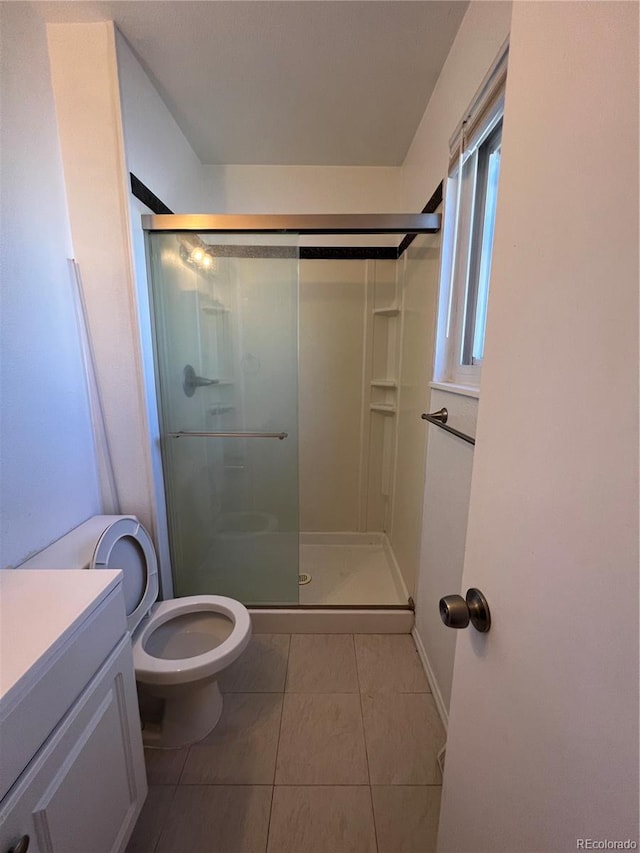 bathroom with vanity, tile patterned floors, toilet, and an enclosed shower