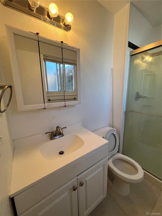 bathroom with vanity, tile patterned floors, toilet, and walk in shower