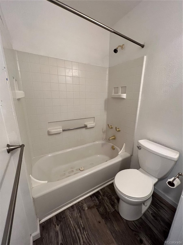 bathroom featuring toilet, hardwood / wood-style flooring, and tiled shower / bath combo