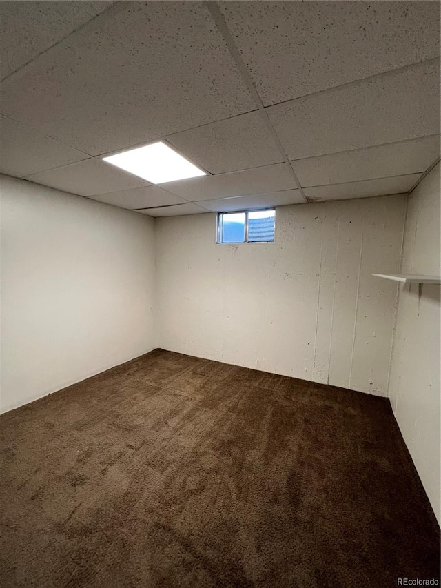 basement with a paneled ceiling and carpet flooring