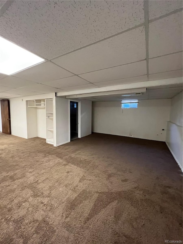 basement with a drop ceiling and carpet floors