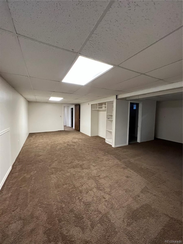 basement with a paneled ceiling and carpet floors