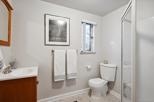 bathroom with walk in shower, vanity, and toilet