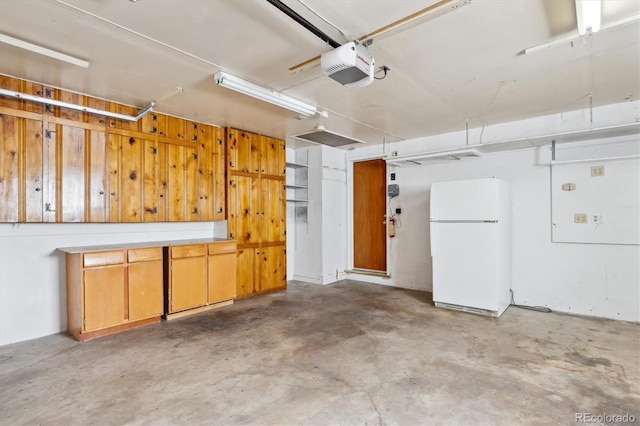 garage with white refrigerator and a garage door opener