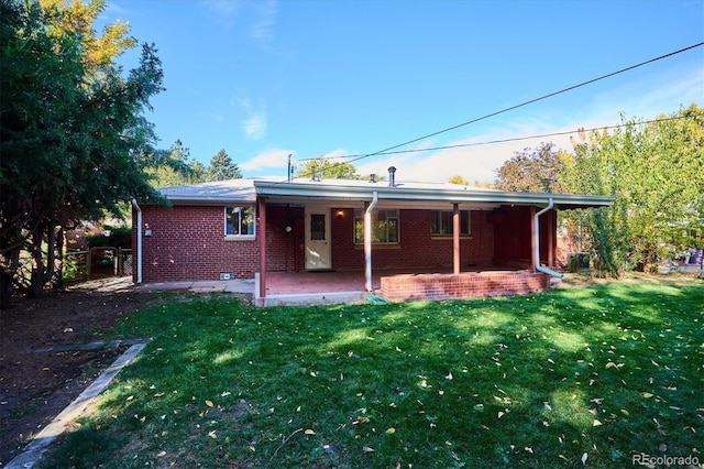 back of house featuring a lawn and a patio area