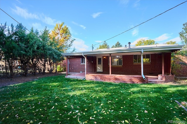 rear view of house featuring a yard and a patio area