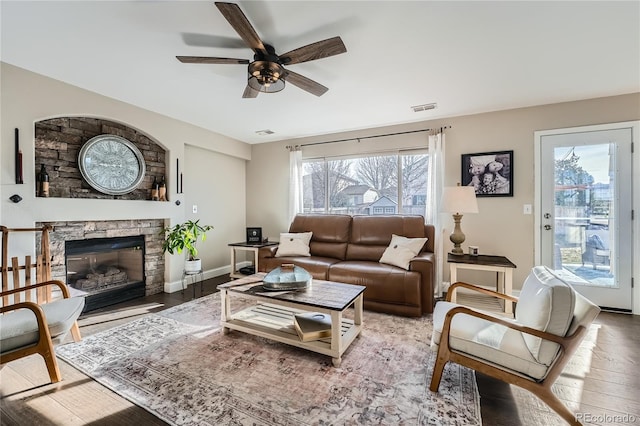 living room featuring ceiling fan, a fireplace, and hardwood / wood-style flooring