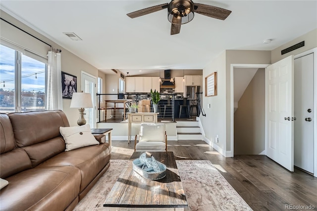 living room with ceiling fan and dark wood-type flooring