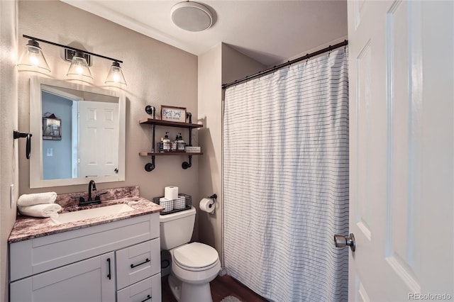 bathroom featuring a shower with curtain, vanity, and toilet