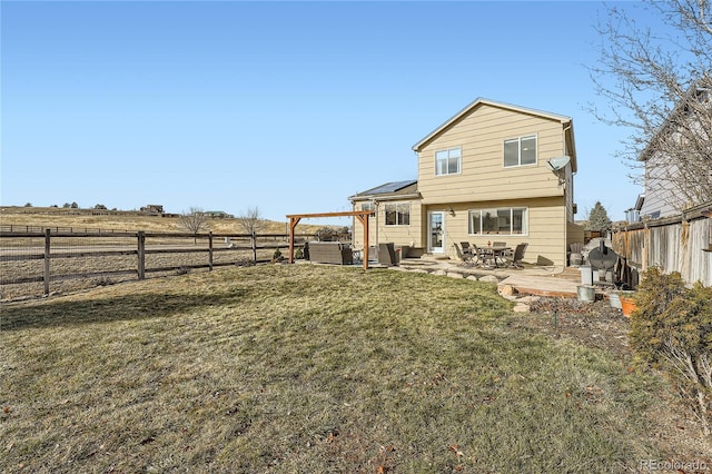 back of property with a pergola, an outdoor hangout area, a rural view, a patio area, and a yard