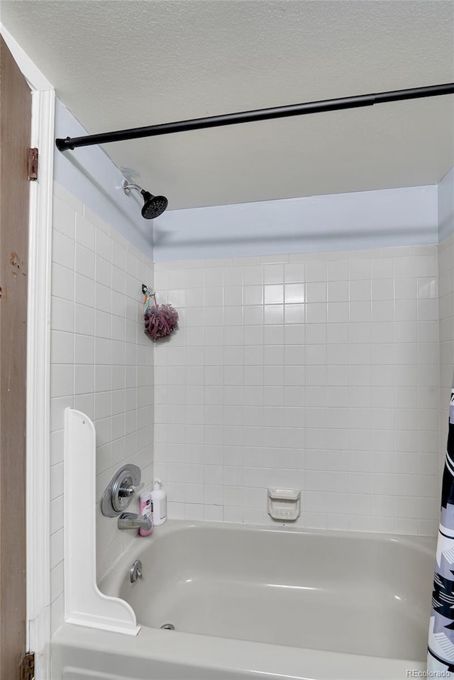 full bathroom featuring shower / bathtub combination with curtain and a textured ceiling