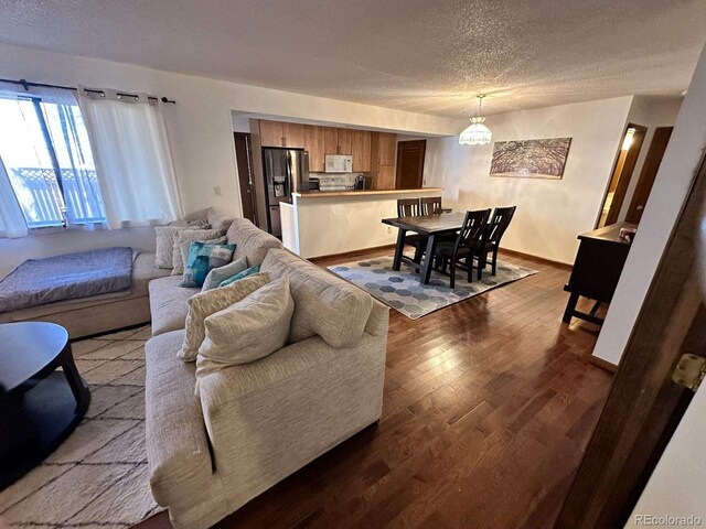 living room featuring baseboards, a textured ceiling, and dark wood finished floors