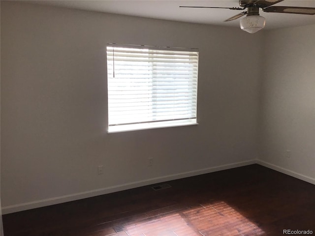 unfurnished room with baseboards, visible vents, wood finished floors, and ceiling fan