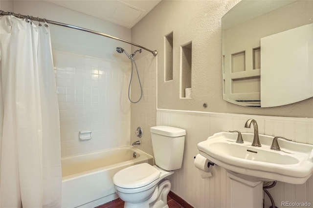 full bathroom with a sink, wainscoting, toilet, and shower / bath combination with curtain
