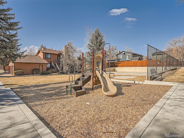 community play area with a residential view and fence