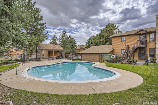 pool featuring fence, a yard, and a patio area