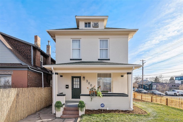 view of front of property with covered porch and a front lawn