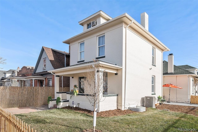 exterior space with covered porch, a front yard, and central AC unit