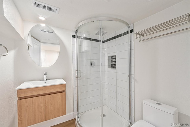 bathroom featuring vanity, toilet, walk in shower, and hardwood / wood-style floors