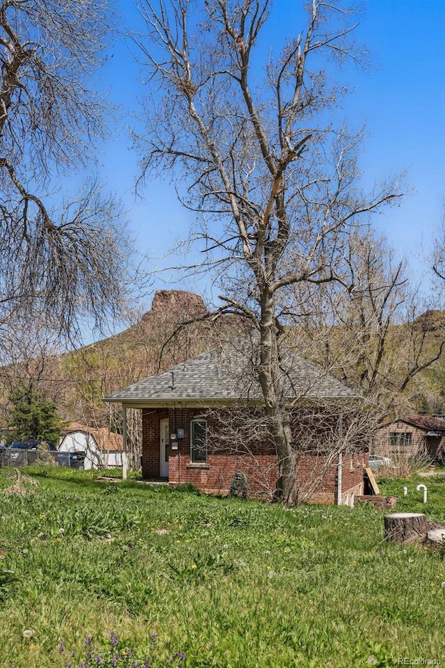 1914 Washington Ave, Golden, CO 80401 - view of front facade featuring brick siding, a front lawn, a mountain view, and a shingled roof