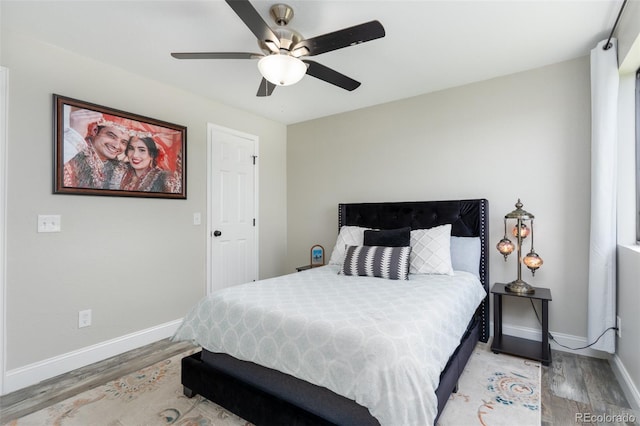 bedroom with ceiling fan, baseboards, and wood finished floors